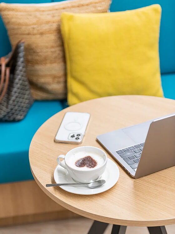 Ein Laptop und ein Kaffee auf einem niedrigen Tisch