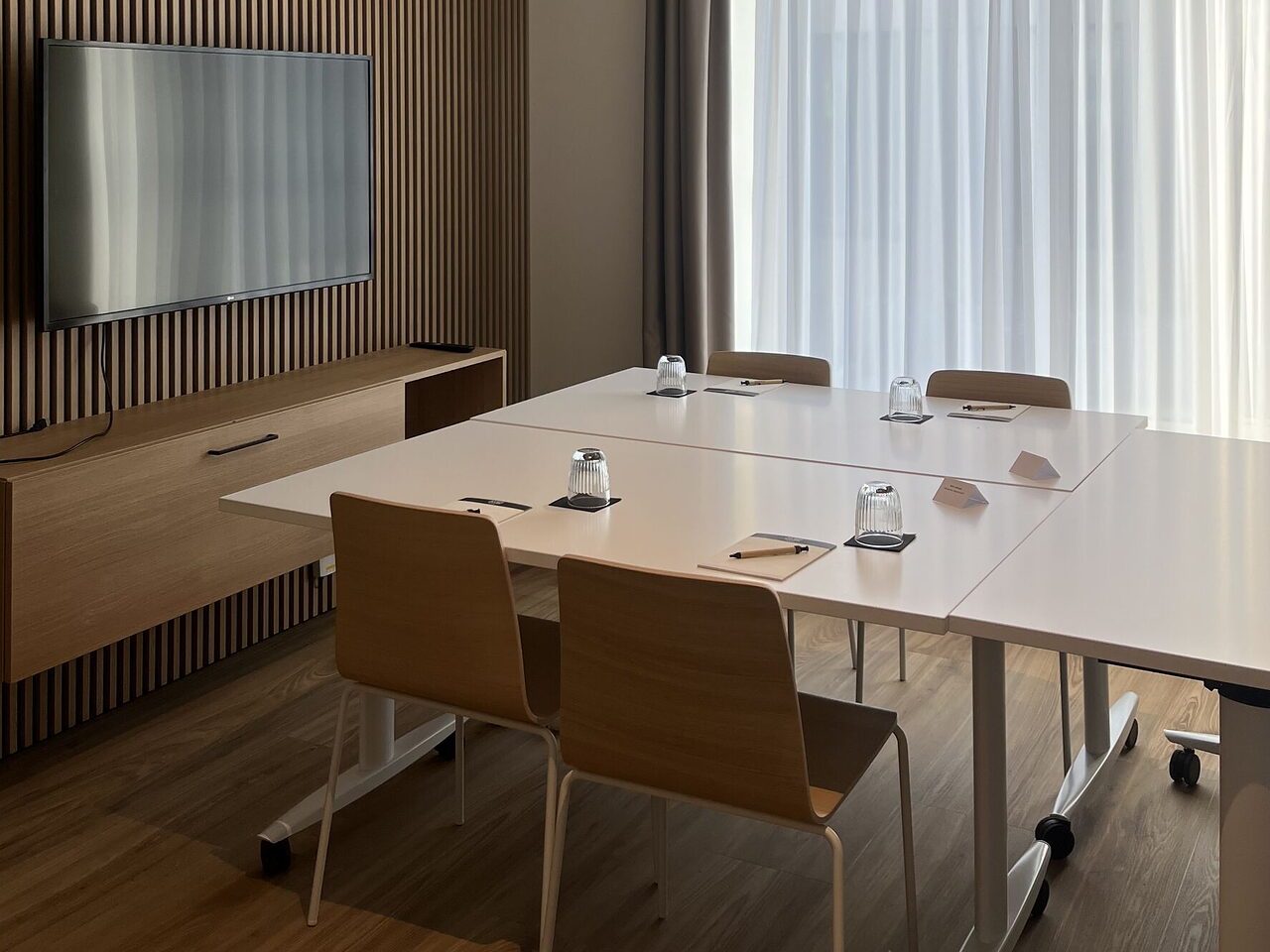 Das Büro 119: Sitzungstisch, Bildschirm und Fensterfront